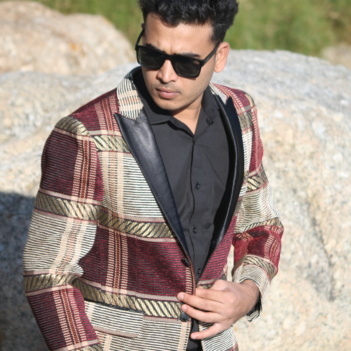 Stylish man wearing a made-to-measure plaid blazer with gold and burgundy tones by Smart Tailor.
